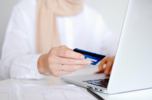 person holding a credit card as their make an online payment